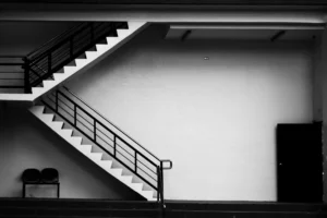 Schody z czarną balustradą prowadzące na piętro budynku