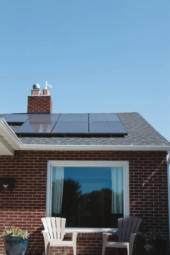 Dwa stojące krzesła przed domem posiadającym panele solarne